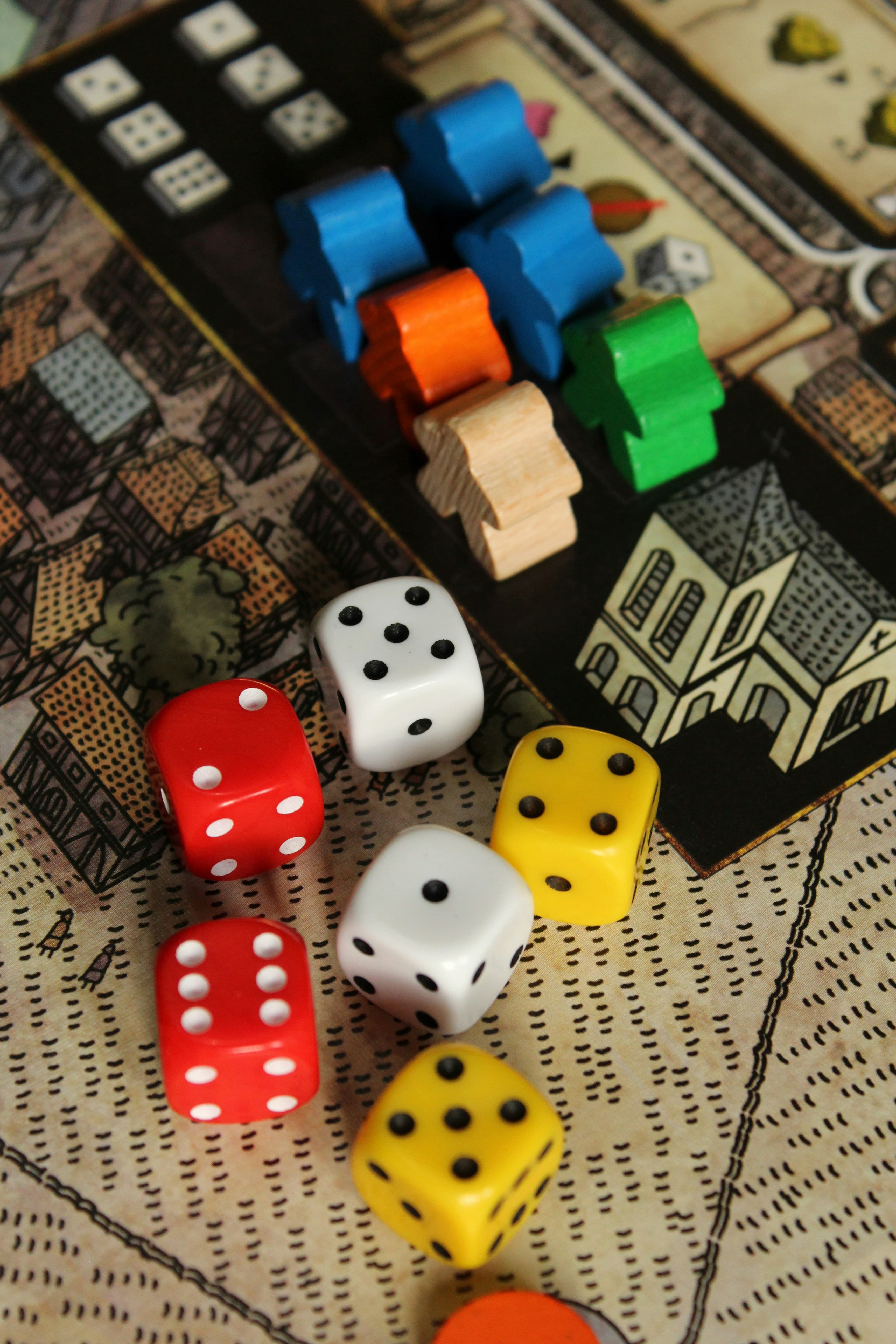 Close up of a board game with dice, cards and other game pieces, representing his love for trivia and trivia contests